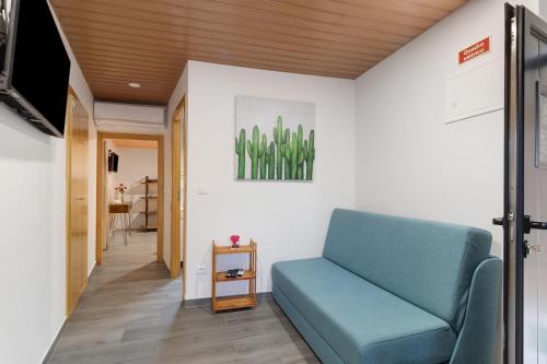 a living room with a blue couch and a television at Casa Da Capela in Entre Ambos os Rios