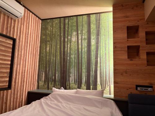 a bedroom with a large window with a forest view at 福井ホテルシルビア in Fukui