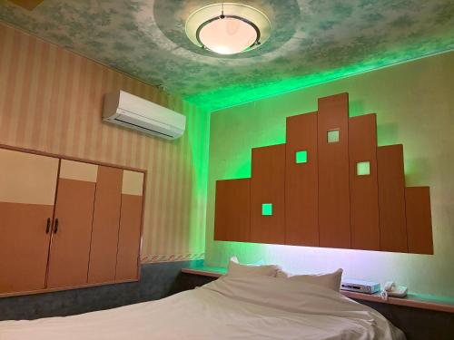 a bedroom with a bed with green lights on it at 福井ホテルシルビア in Fukui