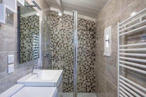a bathroom with a sink and a shower and a mirror at Studio piscine partagée in Bretignolles-sur-Mer