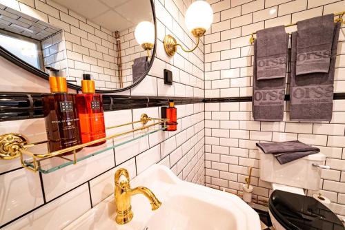 a white bathroom with a sink and a mirror at Orsa Järnvägshotell in Orsa
