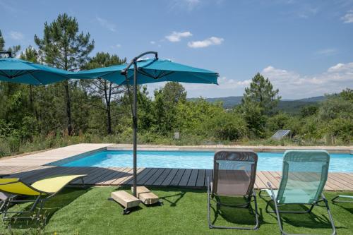 due sedie e un ombrellone accanto a una piscina di Hamlet a Lablachère