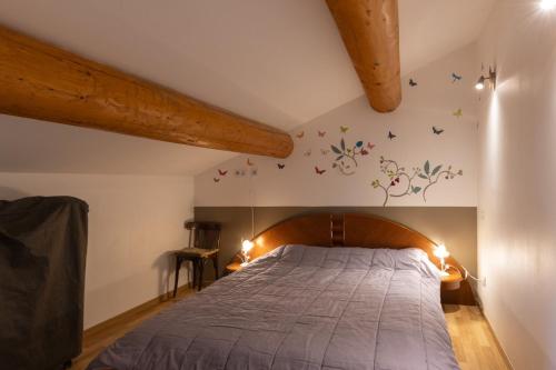 una camera da letto con un letto con testiera in legno di Hamlet a Lablachère