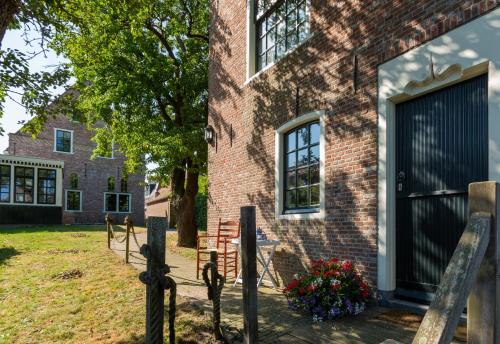a brick house with a fence in front of it at Hylper Huis in Hindeloopen