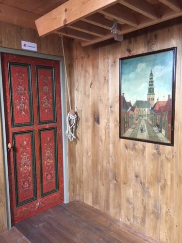 a room with a red door and a painting on the wall at Hylper Huis in Hindeloopen