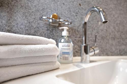 a bathroom sink with towels and a bottle of soap at Sylt Ferienwohnung 1 Westerland in Westerland