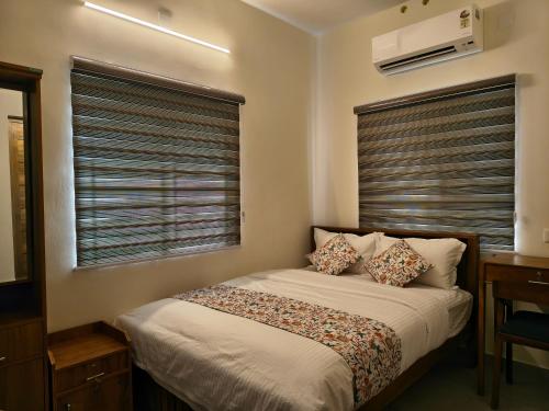 a bedroom with a bed and a window with blinds at IRIS urban stay in Cochin