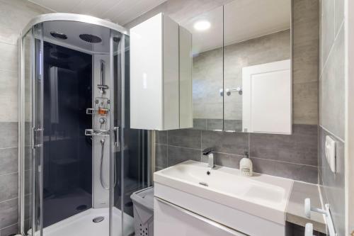 a bathroom with a white sink and a shower at Gite 4 de l'Orée du Bois in Thenon