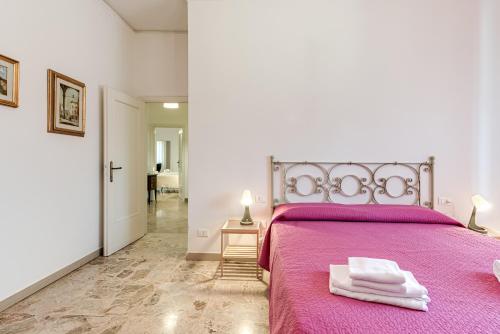 a bedroom with a purple bed with a pink blanket at Depandance Resort in Borgo San Lorenzo