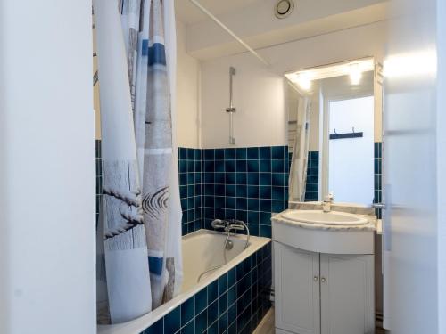 a bathroom with a tub and a sink and a mirror at Ty Fox by Madame est Servie in Perros-Guirec