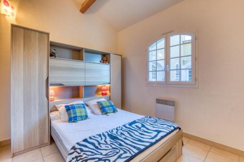 a bedroom with a large bed with blue and white sheets at Madrague St Vincent Apt B in Le Grau-dʼAgde
