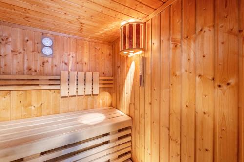 a wooden sauna with a bench and a clock at Domizil Eden - Erdgeschoss in Göhren-Lebbin