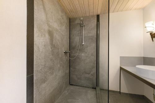 a shower with a glass door in a bathroom at Restaurant Fewo Golsong in Thaleischweiler-Fröschen
