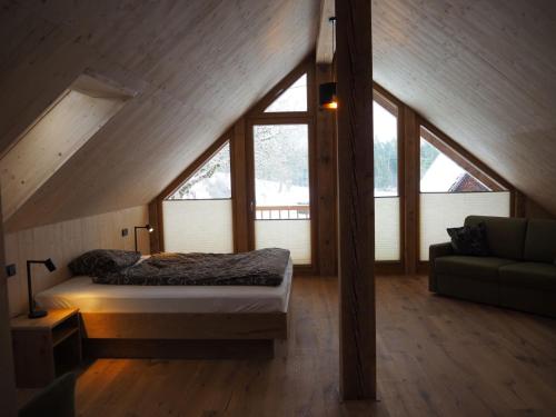 a bedroom with a bed in a attic with windows at Sigmundenhof Schonach in Ölberg