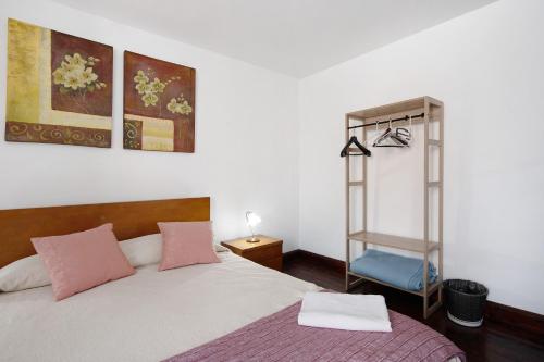 a bedroom with a bed and a shelf at Casa Dona Isaura in Ponta Delgada