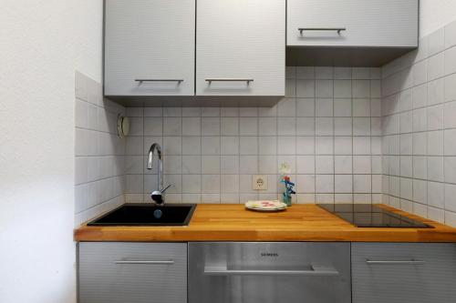 a kitchen with a sink and white cabinets at Fewo Berggipfel am Feldberg in Feldberg