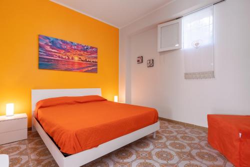 a bedroom with an orange bed in a room at Leondoro - Pirandello in Santa Flavia