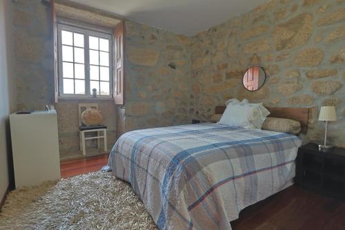a bedroom with a bed and a refrigerator in it at Casa De Vilar do Dão in Penalva do Castelo