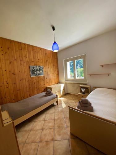 a bedroom with two beds and a window at Casa Nova in Porte di Rendena