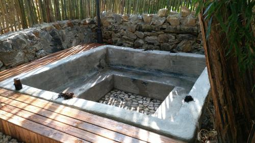 a concrete tub sitting next to a stone wall at The Twelve Manor•Terraces Lodge in Yuanyang
