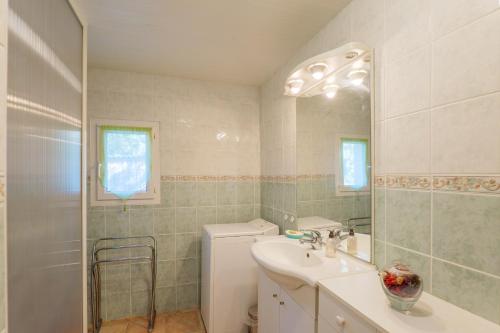 a bathroom with a sink and a toilet and a mirror at Gite de la Troulière in Banne