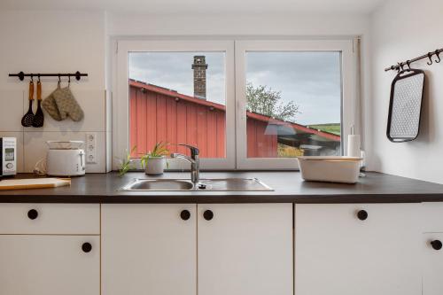 a kitchen counter with a sink and a window at Ferienhaus Engelsberghof in Endingen