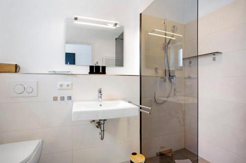 a bathroom with a sink and a shower at Design Ferienwohnung am Chiemsee in Breitbrunn am Chiemsee