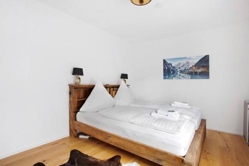 a bedroom with a bed with white sheets at Design Ferienwohnung am Chiemsee in Breitbrunn am Chiemsee