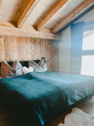 a large bed in a room with wooden walls at Ferienwohnung Katie in Hopfgarten im Brixental
