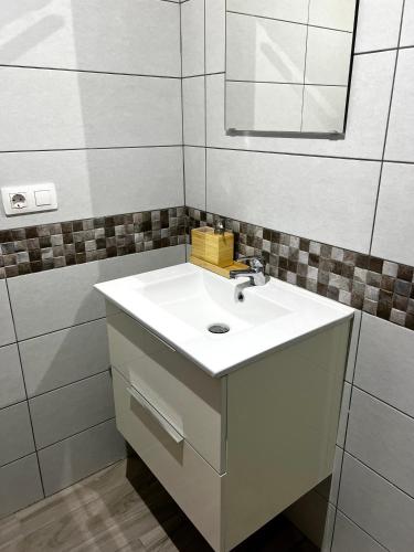 a bathroom with a white sink and a mirror at Bluebell L6 in Armeñime