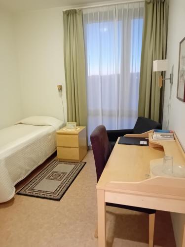a hotel room with a bed and a desk at Birgittaklosteret i Trondheim in Trondheim