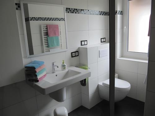 a white bathroom with a sink and a toilet at Ferienwohnung Lortz in Cuxhaven