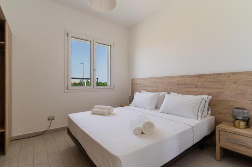 a bedroom with a large white bed with two towels on it at Le scuderie 5 in Galatone