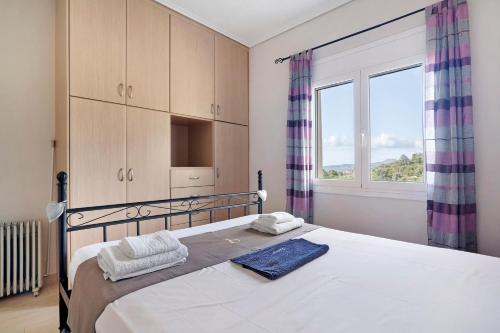 a bedroom with a large bed and a window at Villa Ermina Paleros in Paleros