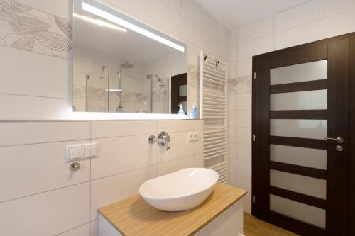 a white bathroom with a sink and a mirror at Lifestyle Ferienhaus in Pouch