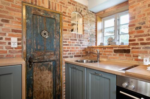 a kitchen with an old wooden door and a sink at Haus am alten Deich in Rodenäs