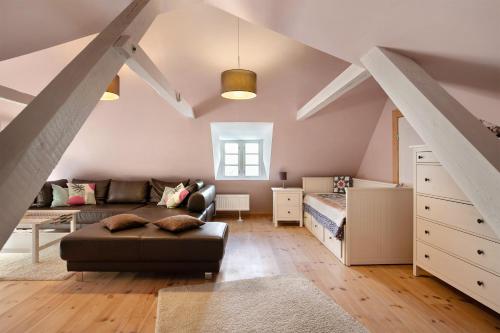 a attic room with a couch and a bed at Haus am alten Deich in Rodenäs