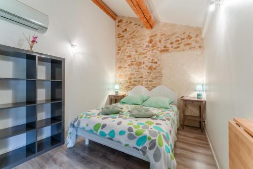 a small bedroom with a bed and a tv at Chambre Olive Verte in Piolenc