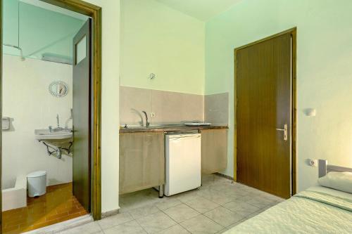 a small kitchen with a sink and a refrigerator at Old Boat double studio 2 in Nikiana