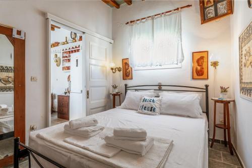 a bedroom with a white bed with towels on it at Penny 's House in Artemonas