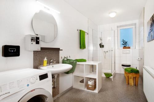 a bathroom with a sink and a washing machine at Wohnung beim Obsthof in Meckenbeuren