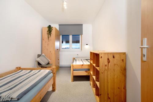 a bedroom with a bed and a desk and a window at Wohnung beim Obsthof in Meckenbeuren