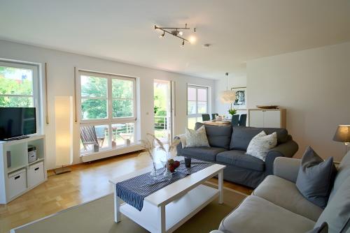 a living room with a couch and a table at Komfort-Ferienwohnung am See in Bodman-Ludwigshafen