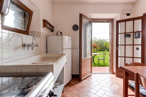 a kitchen with a refrigerator and a table at Il Cerro Appartamento Basic per due in Pelago