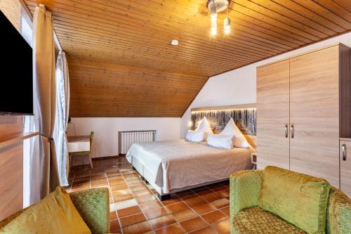 a bedroom with a bed and two chairs in a room at Haus Azalea in Olsberg