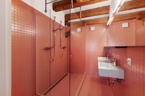 a bathroom with a sink and a shower with red tiles at Villa Arena in Geisingen