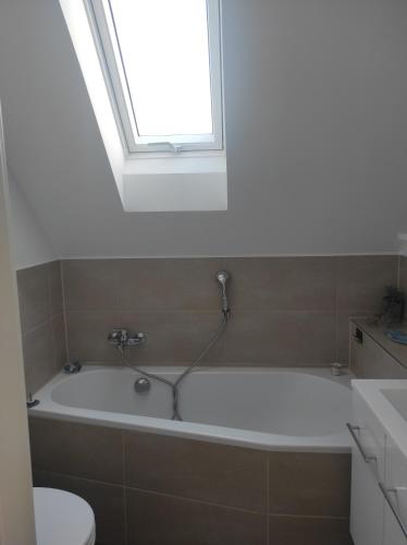 a bathroom with a bath tub with a window at Sachsen Rosie in Hartmannsdorf