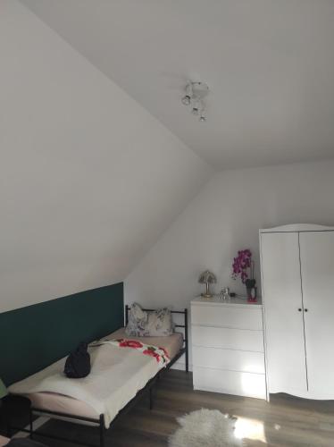 a bedroom with a bed and a white cabinet at Sachsen Rosie in Hartmannsdorf