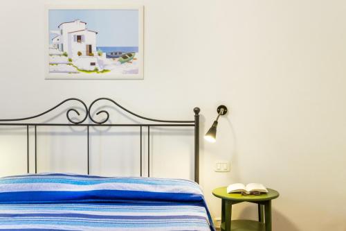 a bedroom with a bed and a table and a picture at Bilo Hedera in Marina di Grosseto