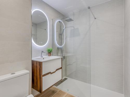 a white bathroom with a sink and a shower at Hanami Avenida de España Oceanfront in Estepona